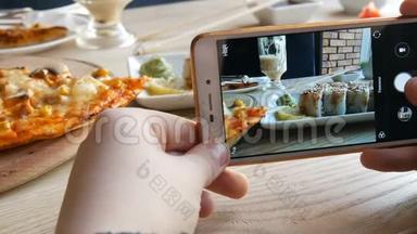 青少年的手在智能手机上制作食物的照片。 一套日本料理的寿司卷和披萨